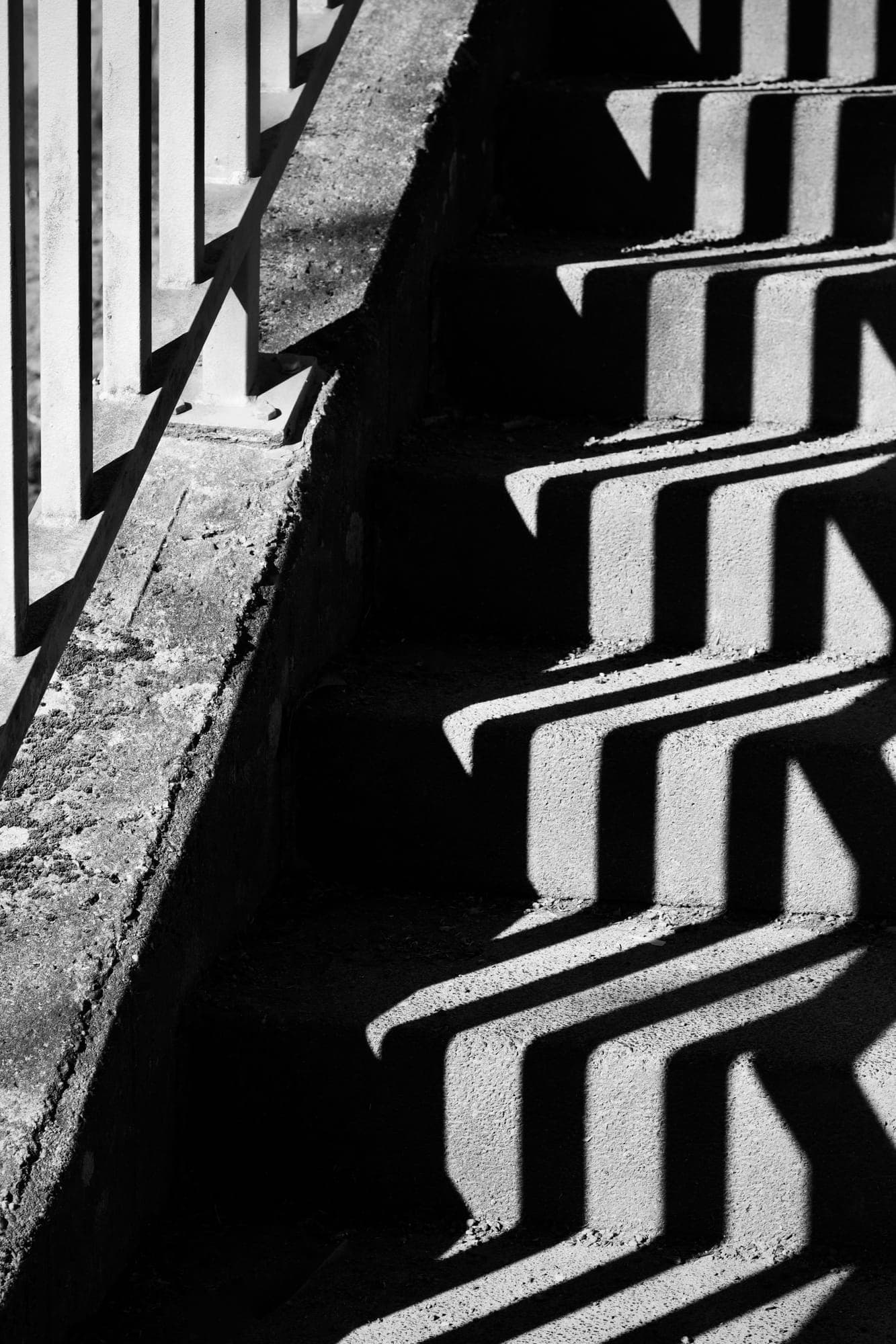 Railing shadows on a concrete staircase