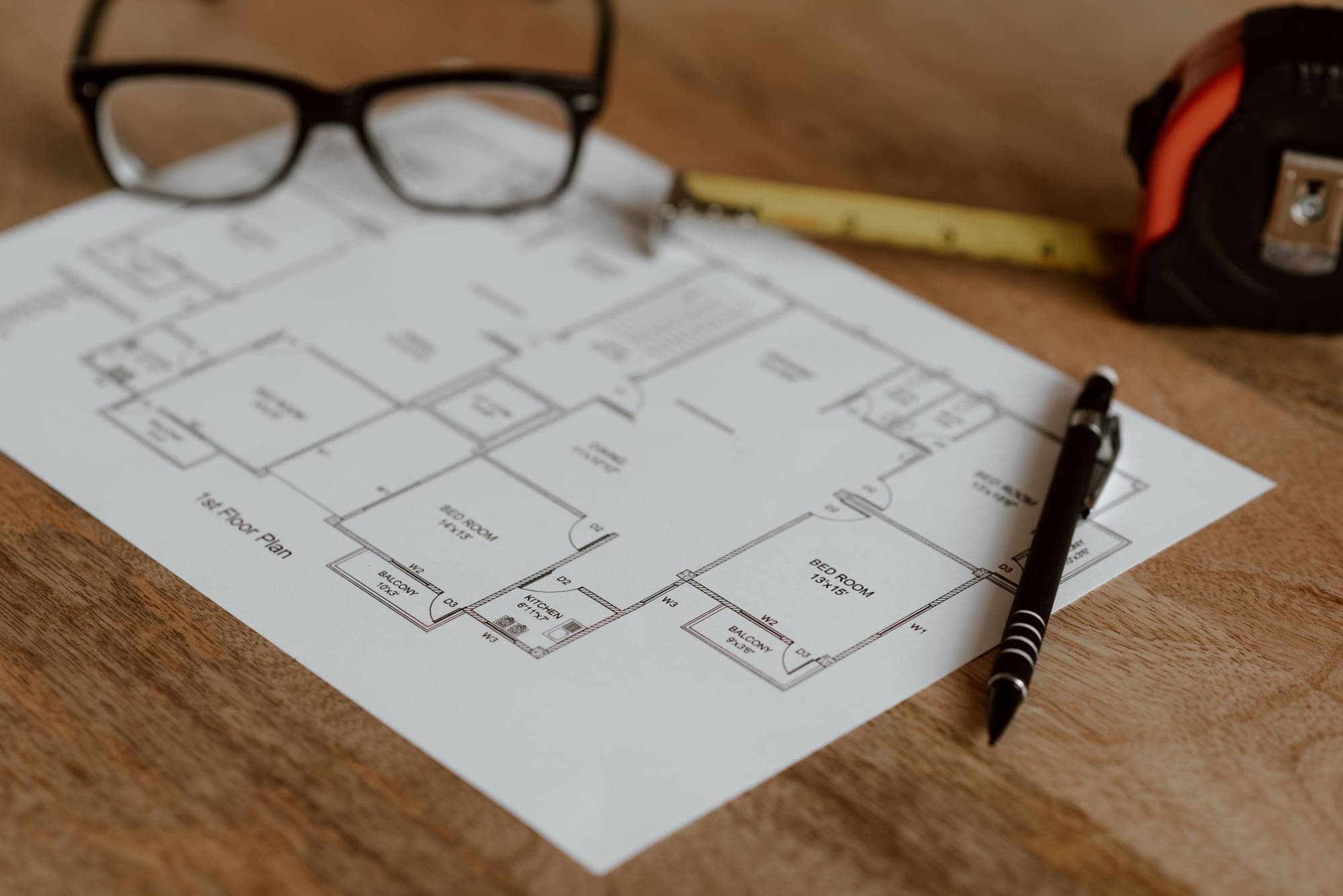 Glasses and a pen on a printed floor plan